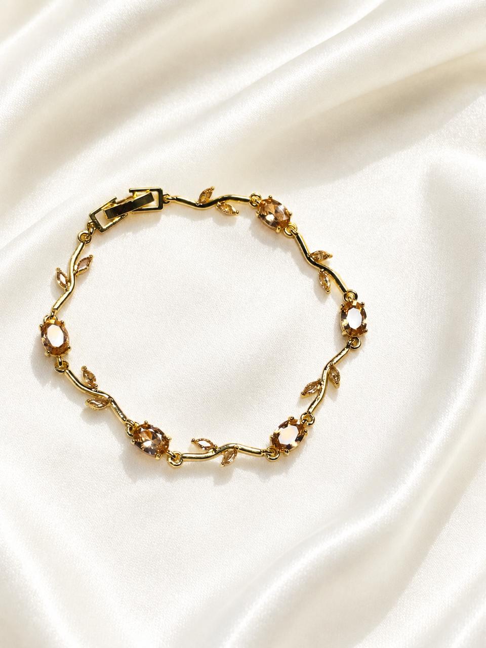 gold-plated vine bracelet features sparkling crystal stones and delicate leaf accents